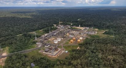 Aerial view of Petrobras' Urucu Base, with golden spherical tanks, industrial structures and pipelines, surrounded by the Amazon rainforest to the horizon