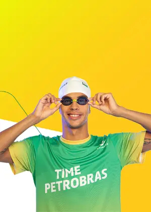 Man with swim cap and goggles, wearing a shirt with 