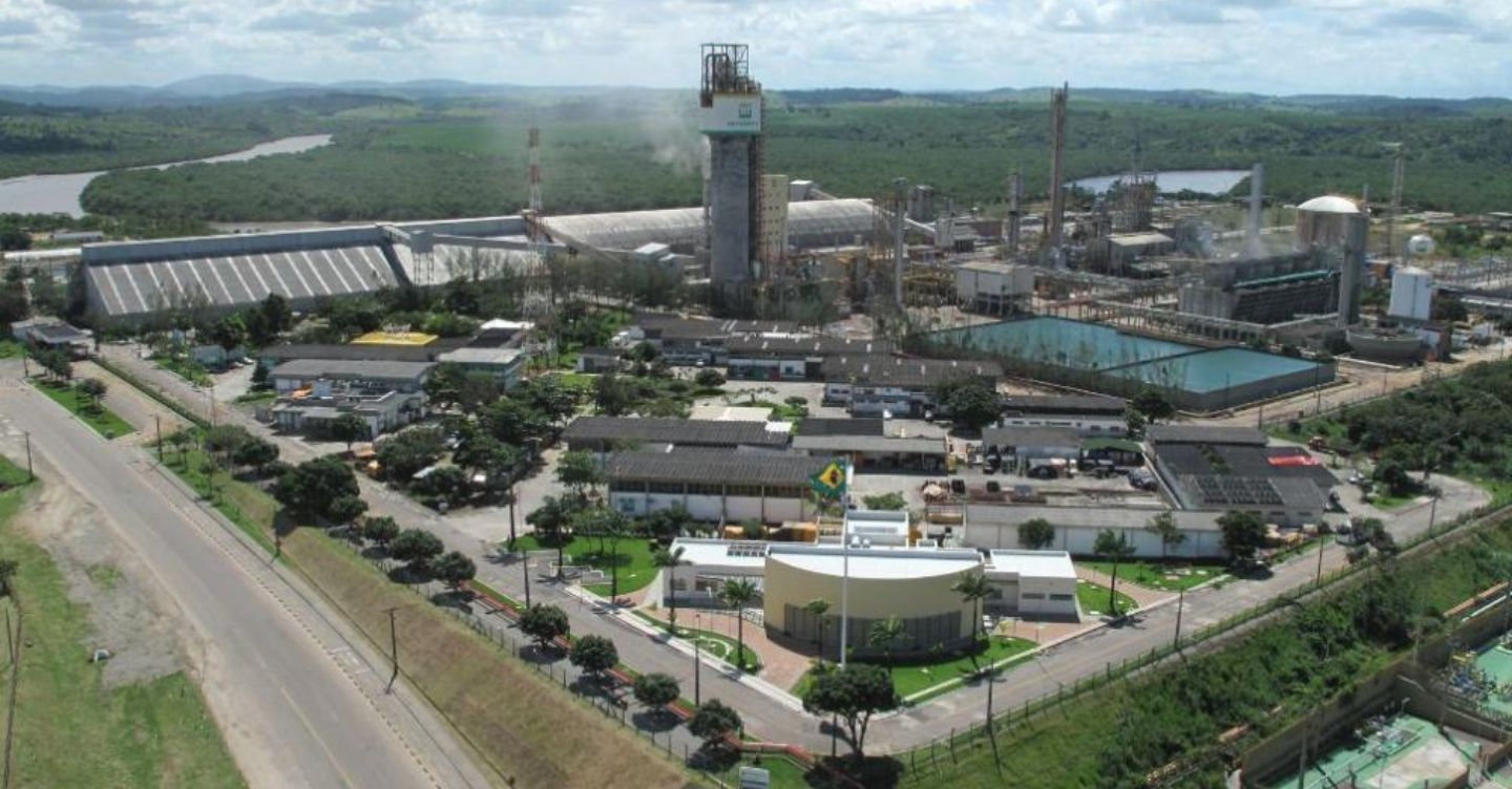 Vista aérea da Fábrica de Fertilizantes Nitrogenados da Petrobras (FAFEN-SE), com estruturas industriais, tanques e prédios administrativos cercados por área verde.