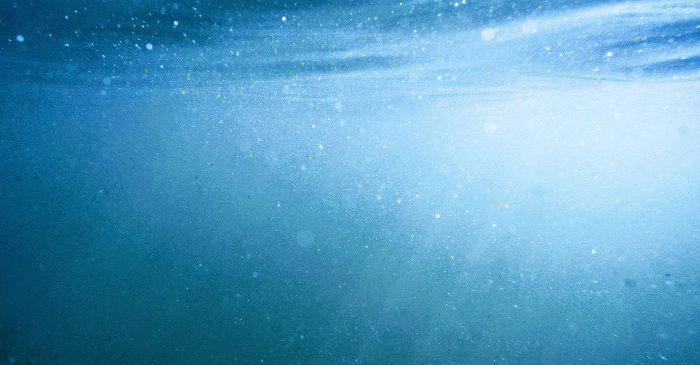 Underwater view with sunlight rays passing through blue water.