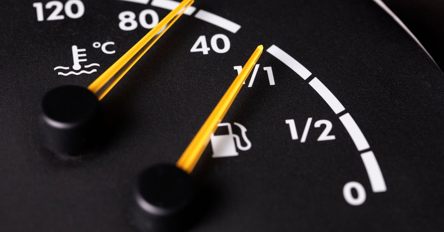 Car dashboard showing fuel level and engine temperature gauges.
