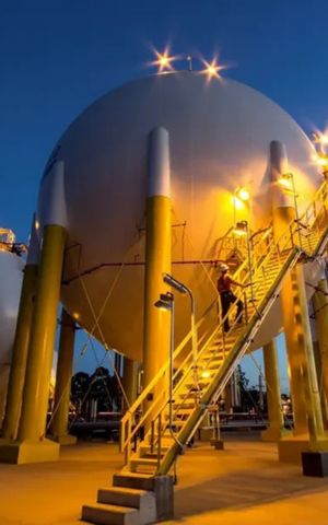 Spherical gas storage tanks at an industrial facility illuminated at night.