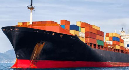 Navio cargueiro com contêineres coloridos navegando no mar.