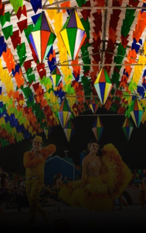 Festa junina com bandeirinhas coloridas, dançarinos e quadrilha em celebração.