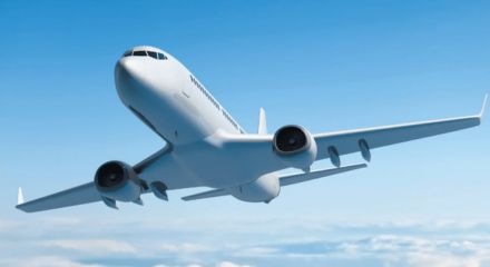 Avião comercial branco em voo sobre nuvens em céu azul.