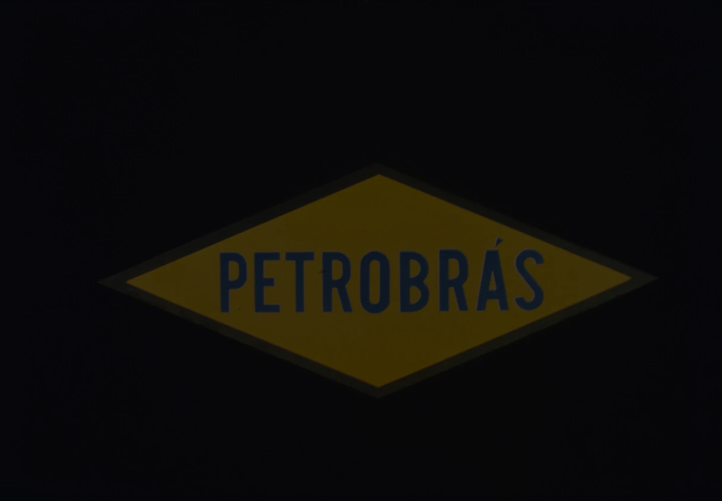 Primeira marca da Petrobras, de 1958; um losango amarelo com bordas azuis e a escrita Petrobrás no centro.