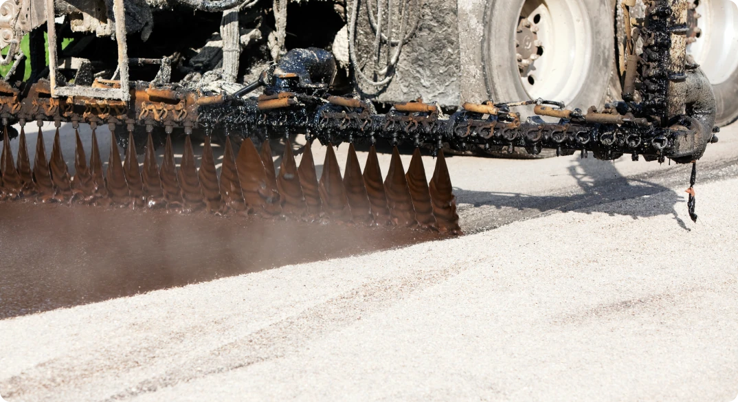 Photo of a machine applying petroleum diluted asphalt.