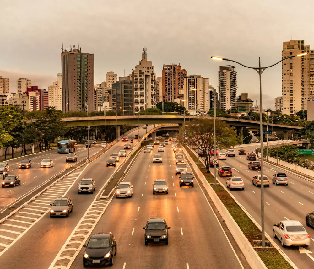 Photo of highways full of cars, in front of a city, representing the use of Petrobras Gasoline.