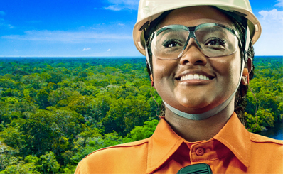 mulher negra de capacete e uniforme com fundo de floresta