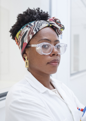 Woman in white coat, goggles and scarf, representing a in Chemical Engineering career at Petrobras.