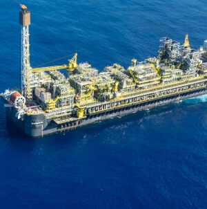 Fotografia aérea diurna de uma plataforma offshore da Petrobras no oceano.