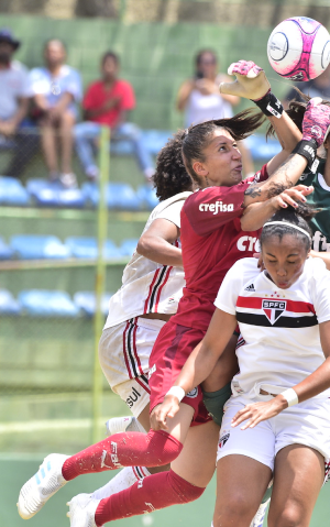 mulheres disputando uma bola numa partida de futebol