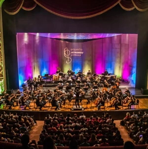 Foto de apresentação da Orquestra Sinfônica Petrobras em um teatro.
