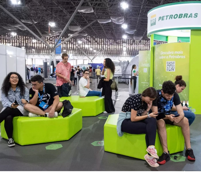 Photo of Petrobras' booth at an event, with different people interacting with each other.