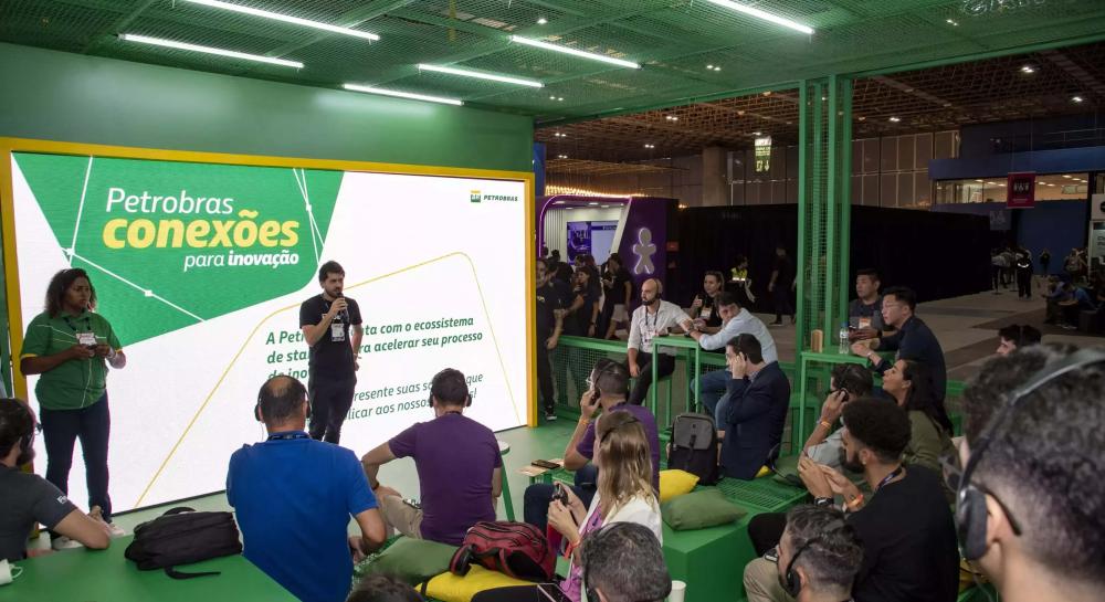 Petrobras representative speaking at Web Summit. Behind him, a projection about Petrobras.