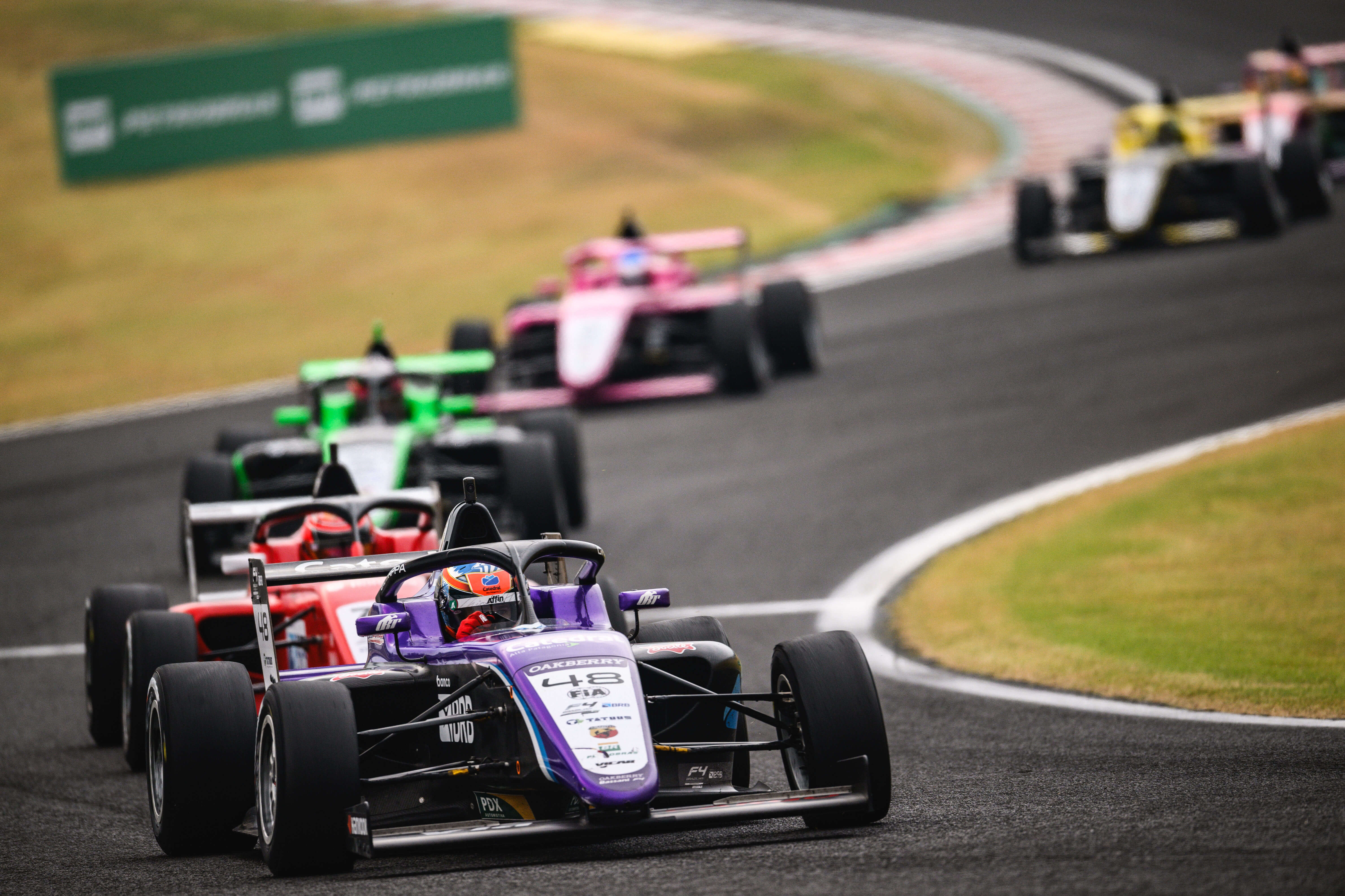 Formula 4 cars take a turn on one of the season's 8 circuits.