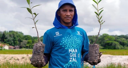 Man wearing a Petrobras shirt involved in the mangrove restoration initiative.