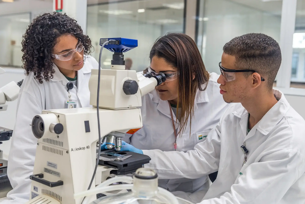 Três jovens realizando experimentos de química na Petrobras