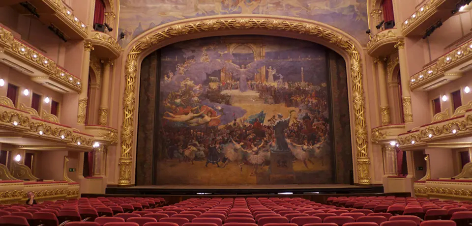 Audience and stage of the Theatro Municipal, with a backdrop panel.