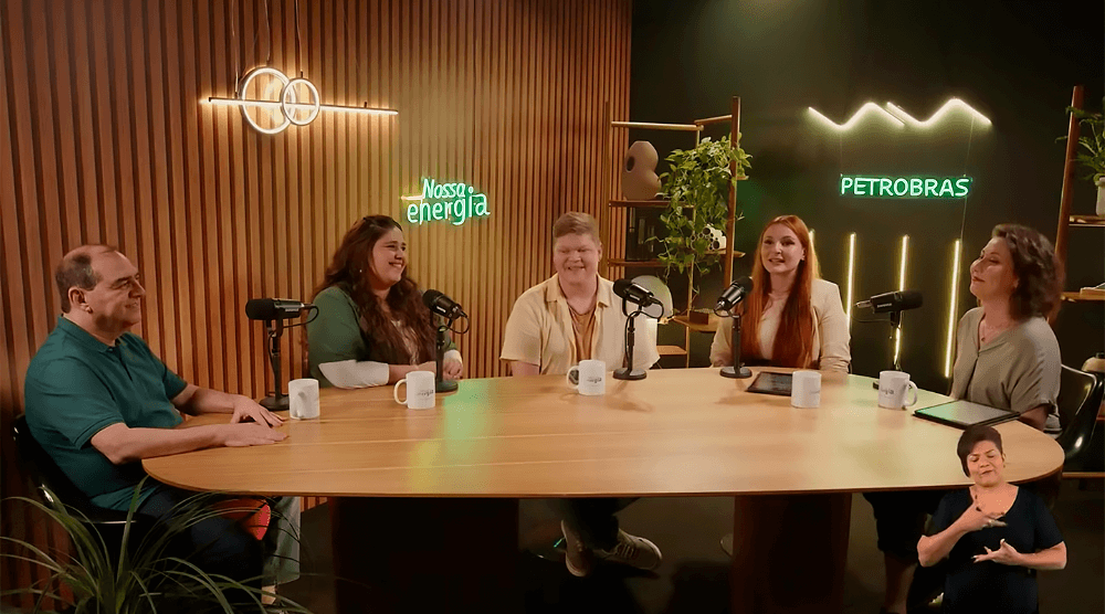 Vinheta com apresentadora e convidados do podcast no cenário do programa.