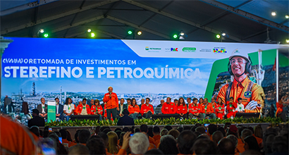 Evento da Petrobras sobre a retomada de investimentos em refino e petroquímica, com o presidente Lula discursando em palco diante de um grande público.