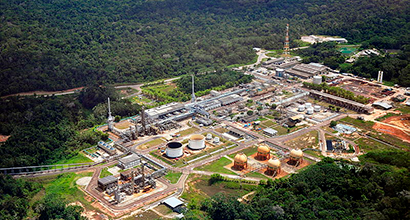 Fotografia diurna aérea de instalações da Petrobras em meio a florestas.