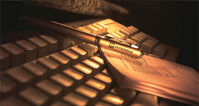 Caneta da Petrobras sobre documento impresso, apoiado em teclado de computador sob iluminação âmbar.