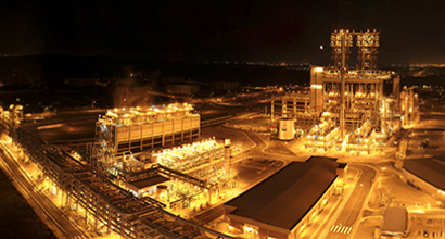 Image of refinery at night, highlighted by lighting.