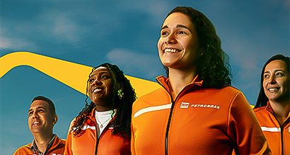 Three women and a man smiling and wearing an orange Petrobras' uniform.