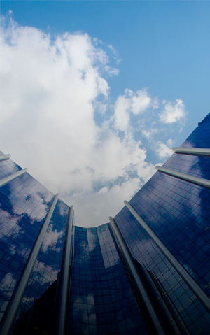 Building with glass facade and a blue sky above it.