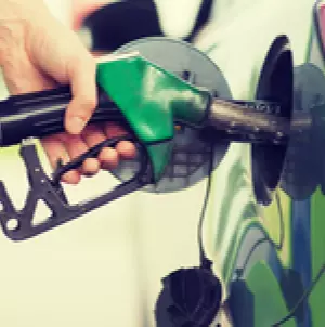 Photograph of a person's hand filling the fuel tank of a car.