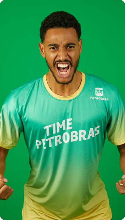 Homem com os braços do lado, em pose de guerreiro. Ele está com uma camiseta escrito Time Petrobras.